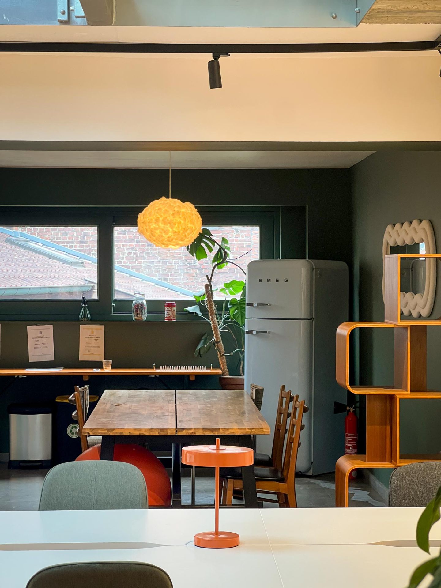 Coin cuisine vert avec frigo SMEG et table en bois